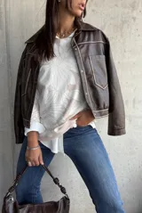 Sweater de punto con diseño floral en tonos crema y natural, de cuello redondo y manga larga.