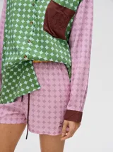 Short de corte boxy confeccionado en viscosa con estampado geométrico de estrellas en tonos rosados. Presenta una pretina elástica en color naranja y cordón de ajuste en color marrón.