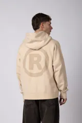 Buzo canguro color marrón con capucha, confeccionado en frisa de algodón. Presenta un diseño gráfico estampado en el frente con texto y logo circular, bolsillo tipo canguro y puños acanalados.