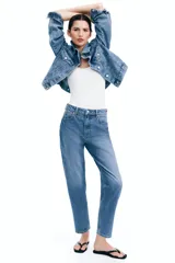 Jean tobillero de tiro alto, color azul medio lavado, con cinco bolsillos y pierna recta ligeramente ajustada.