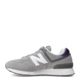 Championes urbanos New Balance modelo 574, color gris con detalles en blanco y negro. Confeccionados en una combinación de gamuza y malla, presentan el logo 'N' característico en los laterales y entresuela con tecnología ENCAP para mayor amortiguación.