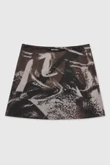 Sobrepollera corta de tul semitransparente con diseño estampado, corte cruzado y lazo lateral ajustable para anudar en la cintura.
