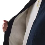 Campera Rhythm Arugam Twill azul marino, con cierre frontal, cuello camisero y bolsillos delanteros. Presenta detalles bordados en amarillo y blanco en los bordes de los bolsillos.