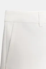 Shorts negros de tiro bajo, corte ajustado y muy corto, con bolsillos delanteros y cierre frontal con cremallera y gancho metálico.