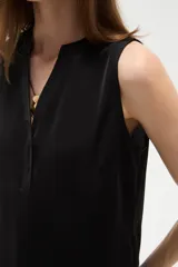 Musculosa de poliéster color blanco, con cuello en V y diseño holgado sin mangas.