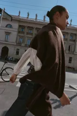 Bufanda de punto fino en color beige, con diseño liso y terminaciones tejidas.