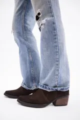 Bota corta estilo western confeccionada en cuero descarne color marrón, con taco cuadrado de madera y punta ligeramente afinada.