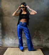 Pantalón de cuero azul brillante, corte jean, tiro medio-alto, con abertura lateral en el ruedo y fabricado en Uruguay.