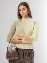 Sweater de punto color beige con diseño de ochos en el frente y mangas raglán. Presenta cuello redondo alto y puños acanalados.