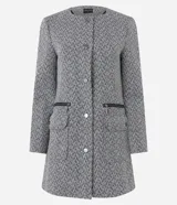 Tapado alargado de poliéster con estampa zigzag en blanco y negro. Tiene cuello redondo, cierre abotonado, mangas largas y bolsillos con cierre.