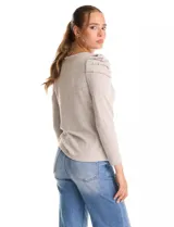 Buzo de tejido soft color gris oscuro, con cuello redondo y mangas largas. Presenta hombros con diseño plisado y detalle de perlas aplicadas.