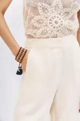 Pantalon palazzo de tiro alto, confeccionado en tejido de cupro y viscosa con textura sedosa. Presenta un diseño de corte recto con caída fluida, largo al piso y bolsillos laterales.