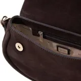 Cartera Guess modelo Danya de formato estructurado y compacto, confeccionada en material sintético con acabado tipo gamuza color marrón. Presenta un asa superior fija con detalle trenzado, correa larga desmontable y ajustable, cierre superior y logo triangular metálico en el frente.