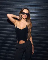 Corset negro con escote corazón pronunciado y corte irregular en el bajo.