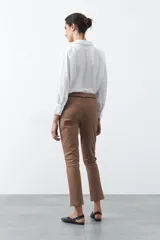 Pantalón de vestir negro de corte recto, con cintura estructurada y costura central vertical en las piernas que aporta un acabado sastrero.