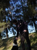 Sweater de lana azul marino con cuello redondo y diseño de copos de nieve y flores en tonos blanco, rojo y violeta. Tejido a mano.