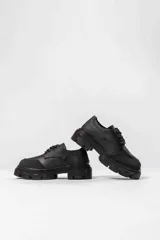 Zapato acordonado de cuero negro con suela track.