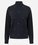 Suéter de punto negro con cuello medio, manga larga y diseño geométrico en relieve. Presenta una delicada aplicación de beads brillantes distribuidos en forma de rombos sobre el frente.