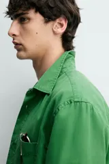 Camisa de corte regular fit en color azul, confeccionada en mezcla de lyocell y algodón, con cuello camisero, manga larga con puños abotonados, cierre frontal con botones y un bolsillo aplicado en el pecho.