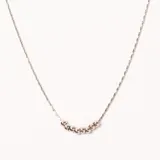 Colgante de acero plateado con cadena fina y nueve cuentas esféricas que forman una curva en la parte central.