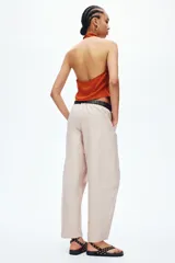 Pantalón cargo de color beige, con perneras estilo globo, cintura elástica y bolsillos laterales de parche.