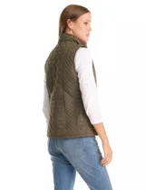 Chaleco capitoneado color verde oliva, con cuello alto, cierre frontal completo y bolsillos laterales. El interior está completamente forrado en símil piel para mayor calidez.