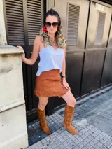 Botas texanas de caña alta en eco gamuza color marrón, con punta afilada y taco bajo. Presentan bordados decorativos en la caña.