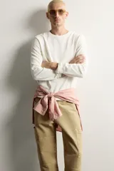 Camiseta relaxed fit de color blanco off-white, confeccionada en tejido texturizado con estructura. Presenta cuello redondo y manga larga.
