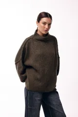 Sweater de punto grueso con cuello alto, diseño de hombros caídos y mangas amplias con puños acanalados.