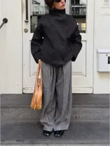 Chaqueta de paño color marrón oscuro, con diseño de doble botonadura frontal y cuello alto estructurado. Presenta mangas largas y un corte recto y holgado.