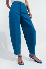Jeans de tiro alto con corte tapered y largo al tobillo. Presenta cinco bolsillos, trabillas en la cintura, cierre frontal con cremallera y botón, y detalle de raya planchada en el frente.