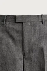Pantalón de traje gris de corte relaxed fit, confeccionado en pura lana, con bolsillos laterales, bolsillos traseros de doble vivo y raya marcada en las piernas.