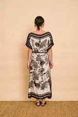 Vestido midi amarillo y blanco con estampado de paisajes y detalles de rayas en el cuello y el dobladillo, de corte holgado, mangas cortas y lazo ajustable en la cintura.