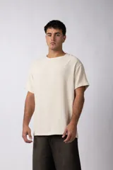 Remera de corte regular confeccionada en una mezcla de rayón y lino con textura entramada. Presenta cuello redondo, mangas cortas y un diseño de estilo rústico y liviano.