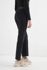 Pantalón de jean azul oscuro, de corte cropped y acampanado, con ruedo desflecado.