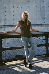 Chaleco de cuello solapa y escote pico cruzado, con hombreras y manga sisa. Presenta bolsillos de vivo en el delantero, forro interior y cierre frontal cruzado con botones. Incluye un cinturón de lazada en el mismo tejido.