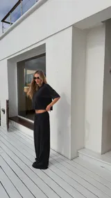 Pantalón negro de algodón y viscosa, con estampado de lunares blancos y corte holgado.