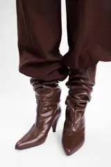 Bota de caña media en cuero negro con diseño slouchy, punta fina y taco cónico de altura media.