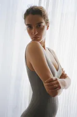 Body gris de punto con escote en pico, tirantes anchos y detalle de tejido rib. Cierre en la parte inferior con botones a presión.