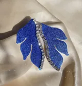Aro dorado con forma de hoja y detalle de strass.
