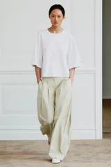 Camiseta de algodón con cuello redondo, manga tres cuartos con detalle de botón metálico y bajo recto.