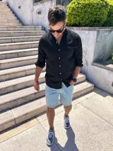 Camisa negra de lino con cuello mao y manga larga con puños abotonados. Cierre frontal con botones a tono.