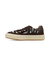 Championes urbanos con diseño de paneles en gamuza marrón y detalles en pelo sintético con estampado animal print de cebra. Presentan suela de plataforma color crema con base de goma y cordones al tono.