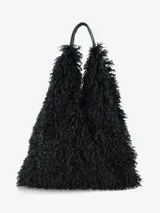 Cartera de diseño amplio y estructura flexible, confeccionada en textura de pelo sintético que aporta volumen. Cuenta con asas cortas integradas para llevar al hombro o en la mano.