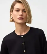Cardigan negro de punto con escote redondo, mangas largas y cierre delantero con botones dorados.