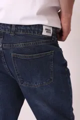 Pantalón de jean azul oscuro, corte recto, con bolsillos delanteros y traseros.