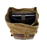 Mochila de tela canvas color negro con solapa y detalles en cuero sintético marrón. Presenta un cierre superior tipo marinero con cordón ajustable, solapa principal con correas y hebillas, y un bolsillo frontal con solapa. Posee bolsillos laterales con cierre metálico y correas de hombro ajustables.