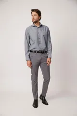 Pantalón gris de corte slim, confeccionado en algodón y spandex. Presenta cierre con botón y cremallera, bolsillos laterales y traseros. Incluye cinturón de cuero negro.