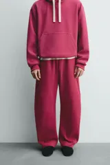 Pantalón jogger relaxed fit color bordó, confeccionado en tejido con algodón e interior forrado en tejido polar. Cuenta con cintura elástica, bolsillos frontales, bolsillos traseros de vivo y detalle de costura frontal en las perneras.