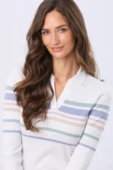 Remera polo de manga larga, color blanco con rayas horizontales en tonos pastel (lila, beige, verde menta). Tiene cuello tipo polo y escote en V.